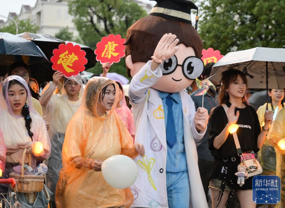 6月21日，威廉希尔体育员工在校园里冒雨巡游。2