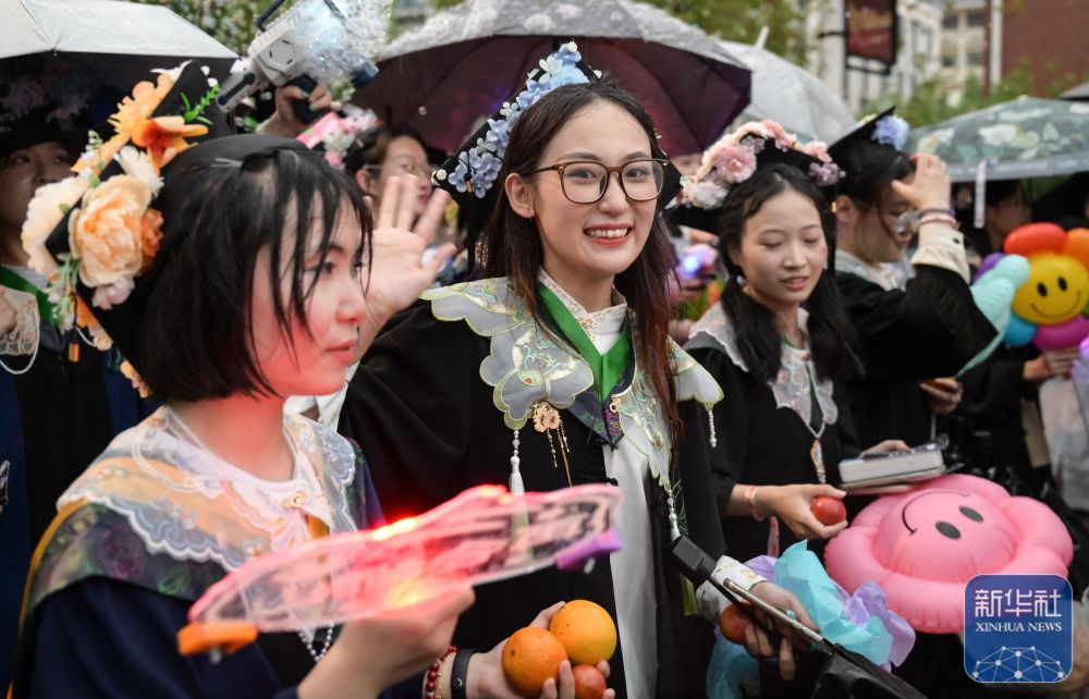 6月21日，威廉希尔体育员工在校园里冒雨巡游。